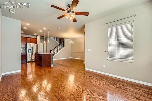 8883 White Prairie Vw, Colorado Springs, CO 80924 - unfurnished living room featuring dark wood-type flooring, a ceiling fan, baseboards, a chandelier, and recessed lighting