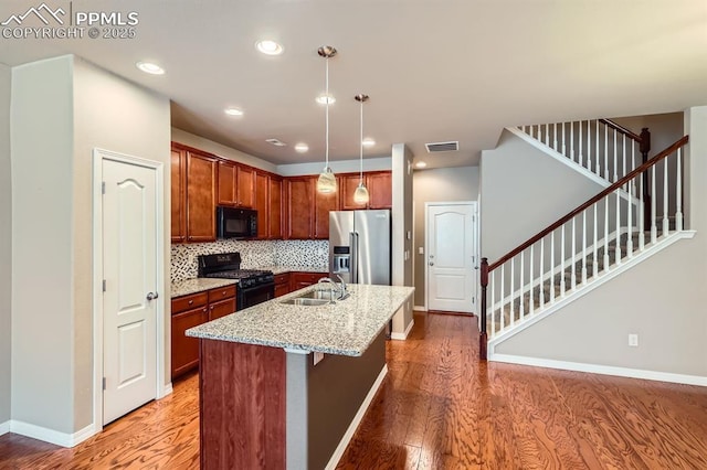 8883 White Prairie Vw, Colorado Springs, CO 80924 - kitchen with black appliances, a sink, light wood-style floors, light stone counters, and recessed lighting