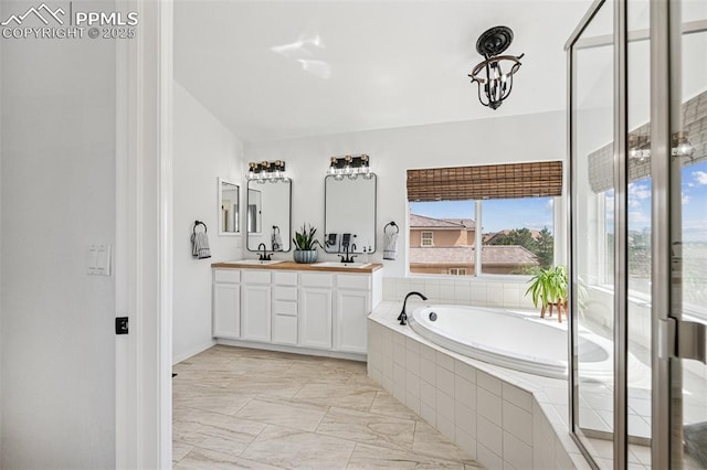 full bathroom with a garden tub, double vanity, marble finish floors, and baseboards