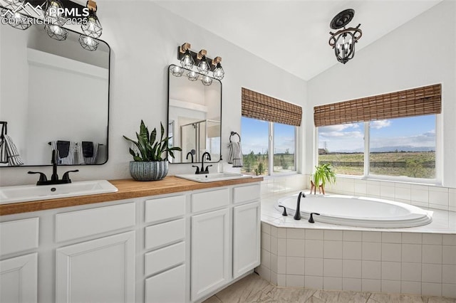 full bath with lofted ceiling, a bath, double vanity, a shower with door, and marble look tile flooring