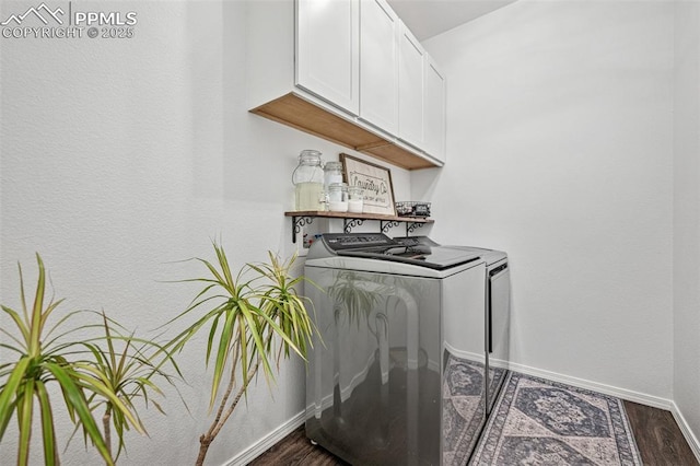 washroom featuring washing machine and clothes dryer, cabinet space, dark wood finished floors, and baseboards