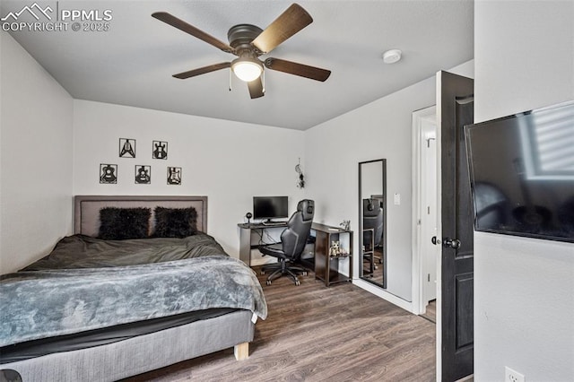 bedroom with wood finished floors, a desk, and ceiling fan