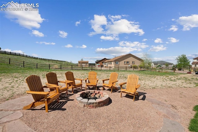 view of patio featuring an outdoor fire pit, fence, and a rural view