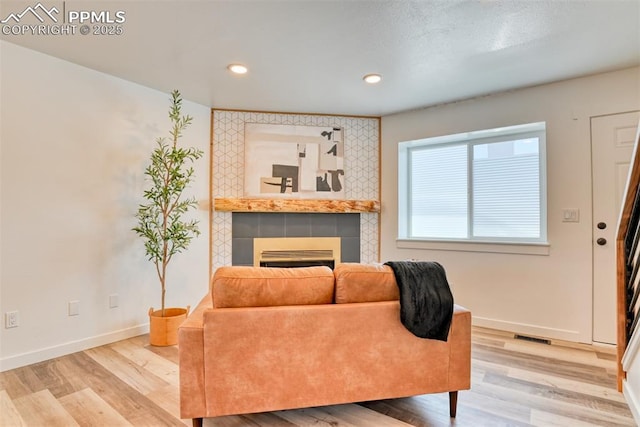 1228 Soaring Eagle Dr, Colorado Springs, CO 80915 - living room featuring a tiled fireplace, baseboards, wood finished floors, and recessed lighting