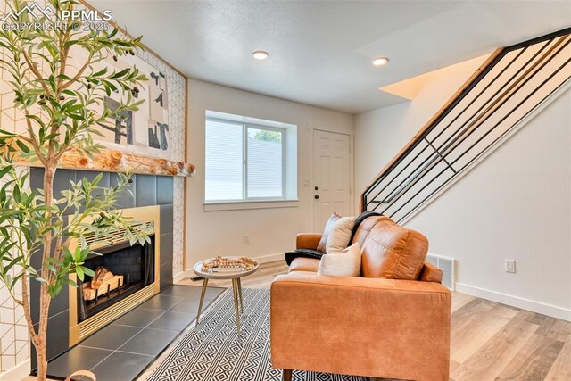 1228 Soaring Eagle Dr, Colorado Springs, CO 80915 - living area with a tiled fireplace, baseboards, stairway, recessed lighting, and wood finished floors