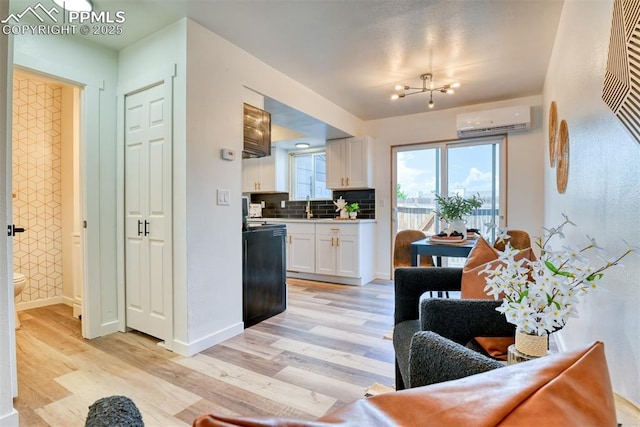 1228 Soaring Eagle Dr, Colorado Springs, CO 80915 - living area featuring an AC wall unit, light wood finished floors, and baseboards