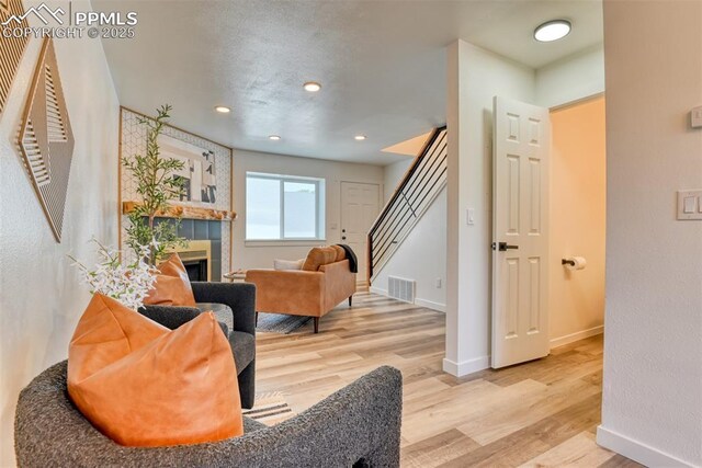 1228 Soaring Eagle Dr, Colorado Springs, CO 80915 - living area featuring stairs, wood finished floors, baseboards, a fireplace, and recessed lighting