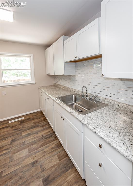 909 E Costilla St, Colorado Springs, CO 80903 - kitchen with a sink, tasteful backsplash, white cabinets, and baseboards