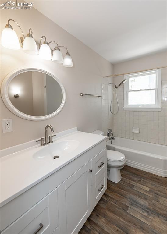 909 E Costilla St, Colorado Springs, CO 80903 - full bath featuring toilet, vanity, wood finished floors, and tub / shower combination