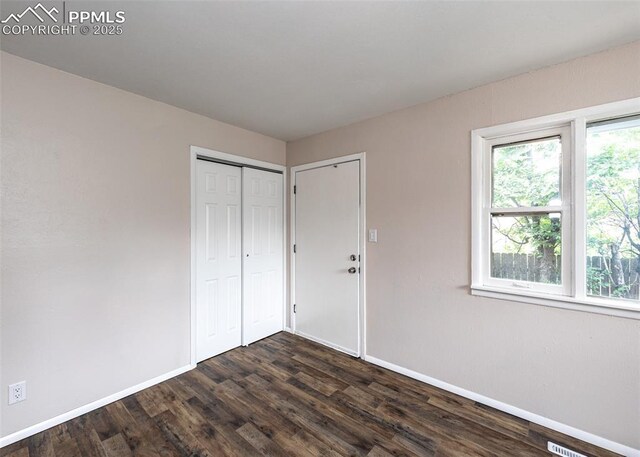909 E Costilla St, Colorado Springs, CO 80903 - unfurnished bedroom featuring baseboards, dark wood-type flooring, and a closet