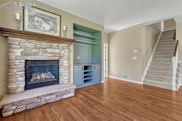 2044 Coldstone Way, Colorado Springs, CO 80921 - unfurnished living room featuring wood finished floors, stairway, a fireplace, and baseboards