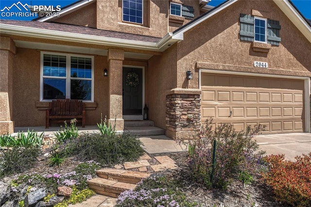 2044 Coldstone Way, Colorado Springs, CO 80921 - view of front of home with stucco siding, covered porch, driveway, stone siding, and an attached garage