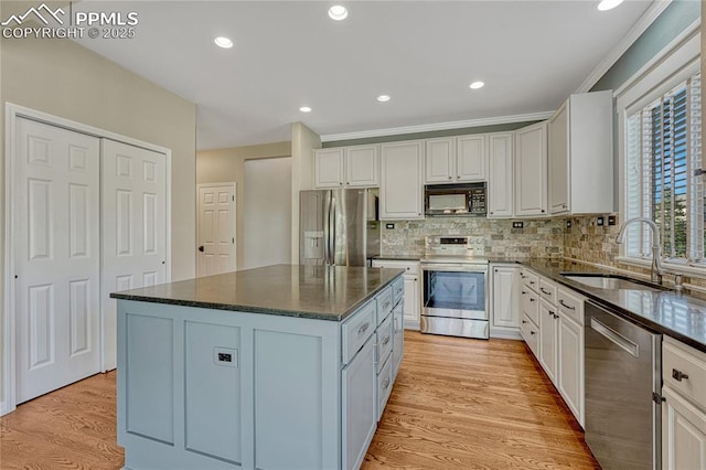 2044 Coldstone Way, Colorado Springs, CO 80921 - kitchen with appliances with stainless steel finishes, a sink, tasteful backsplash, light wood-style floors, and ornamental molding