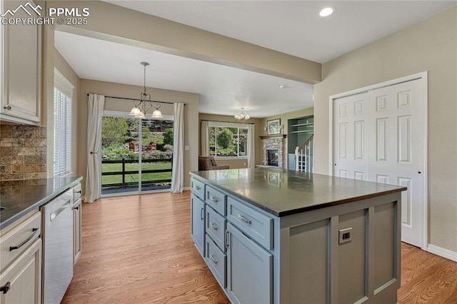 2044 Coldstone Way, Colorado Springs, CO 80921 - kitchen featuring a chandelier, dishwashing machine, light wood finished floors, decorative backsplash, and pendant lighting