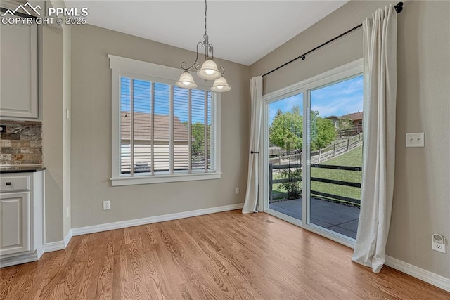 2044 Coldstone Way, Colorado Springs, CO 80921 - unfurnished dining area featuring light wood-type flooring, a chandelier, and baseboards