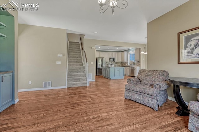 2044 Coldstone Way, Colorado Springs, CO 80921 - sitting room featuring stairway, light wood-style flooring, a chandelier, and baseboards