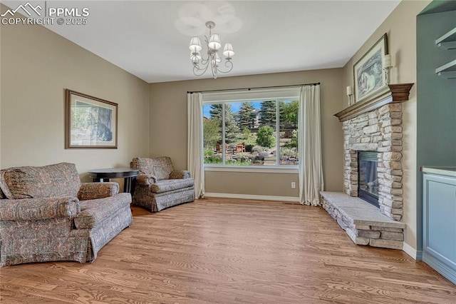 2044 Coldstone Way, Colorado Springs, CO 80921 - sitting room featuring wood finished floors, a chandelier, a fireplace, and baseboards