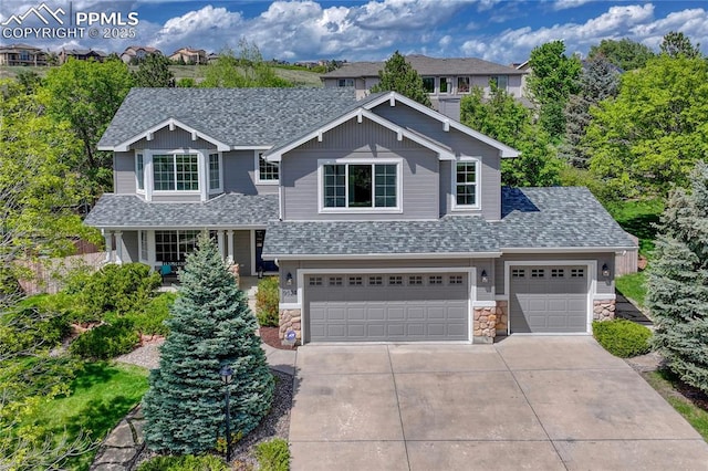 9524 Pinebrook Way, Colorado Springs, CO 80920 - view of front of house featuring driveway, stone siding, roof with shingles, and an attached garage