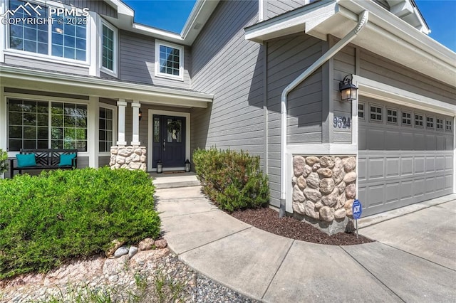 9524 Pinebrook Way, Colorado Springs, CO 80920 - entrance to property featuring a porch, stone siding, driveway, and an attached garage