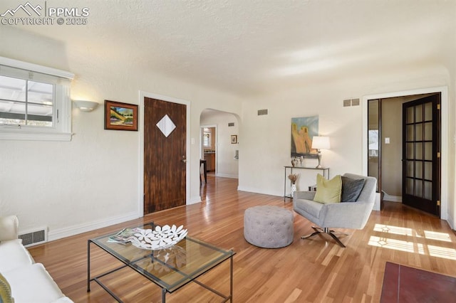 1003 N Institute St, Colorado Springs, CO 80903 - living area featuring arched walkways, wood finished floors, and baseboards