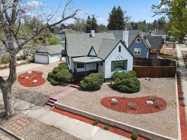 1003 N Institute St, Colorado Springs, CO 80903 - tudor house featuring stucco siding, roof with shingles, a garage, a chimney, and concrete driveway