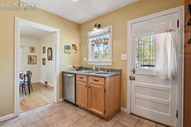 1003 N Institute St, Colorado Springs, CO 80903 - kitchen with dishwasher, a sink, light tile patterned floors, and baseboards