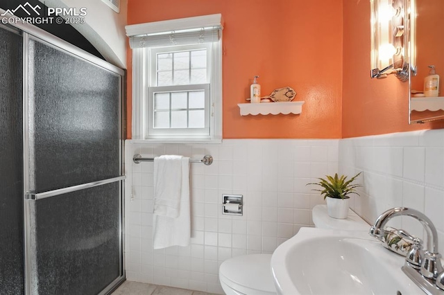 1003 N Institute St, Colorado Springs, CO 80903 - bathroom featuring a sink, tile walls, a shower stall, toilet, and a wainscoted wall