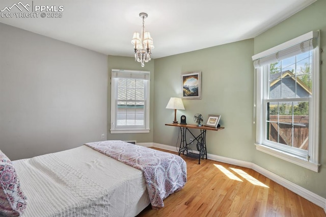 1003 N Institute St, Colorado Springs, CO 80903 - bedroom with multiple windows, a chandelier, and wood finished floors