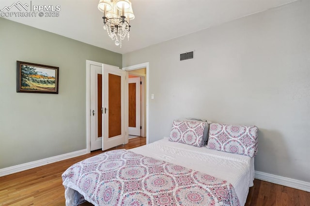 1003 N Institute St, Colorado Springs, CO 80903 - bedroom with a chandelier, baseboards, and wood finished floors