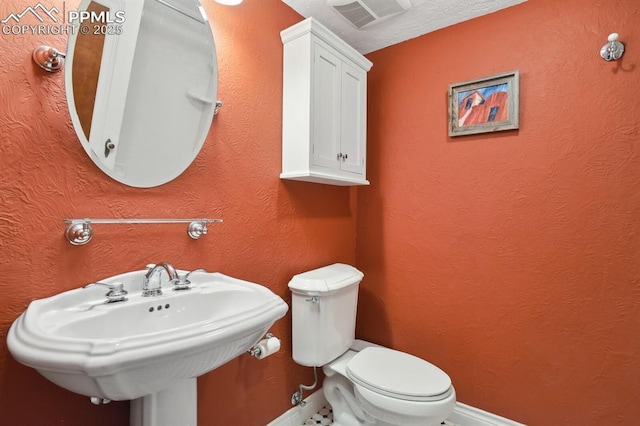 1003 N Institute St, Colorado Springs, CO 80903 - half bathroom featuring baseboards, toilet, and a sink