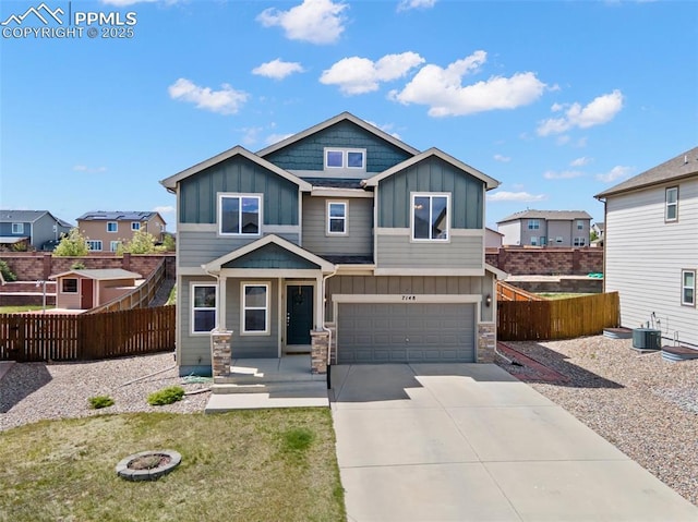 view of front of home featuring board and batten siding, stone siding, central air condition unit, driveway, and a garage