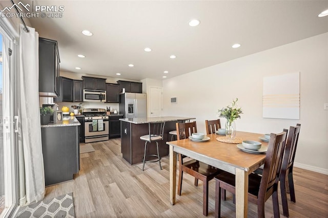 dining space with light wood-style floors, recessed lighting, and baseboards