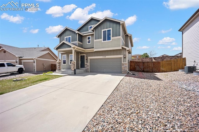 craftsman inspired home with board and batten siding, stone siding, fence, concrete driveway, and central AC