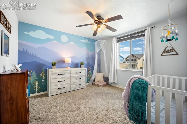 bedroom with carpet flooring, a ceiling fan, a crib, and baseboards