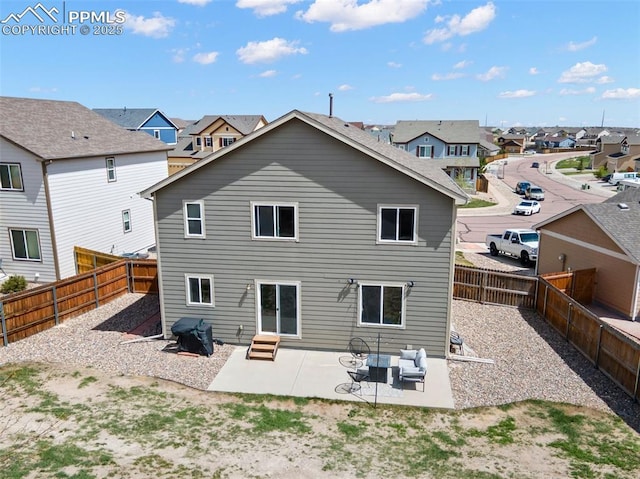 back of property featuring a residential view, a patio area, and a fenced backyard
