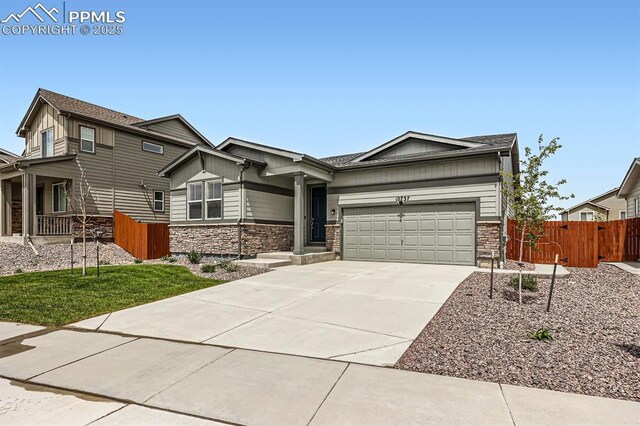 10737 Rolling Mesa Dr, Falcon, CO 80831 - craftsman inspired home featuring stone siding, fence, concrete driveway, a garage, and board and batten siding