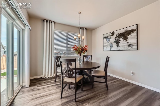 10737 Rolling Mesa Dr, Falcon, CO 80831 - dining room featuring wood finished floors, baseboards, and a chandelier