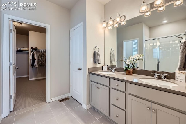 10737 Rolling Mesa Dr, Falcon, CO 80831 - full bath featuring a shower stall, double vanity, tile patterned flooring, a walk in closet, and baseboards