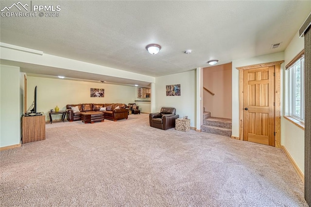 living room featuring stairway, carpet, a textured ceiling, and baseboards