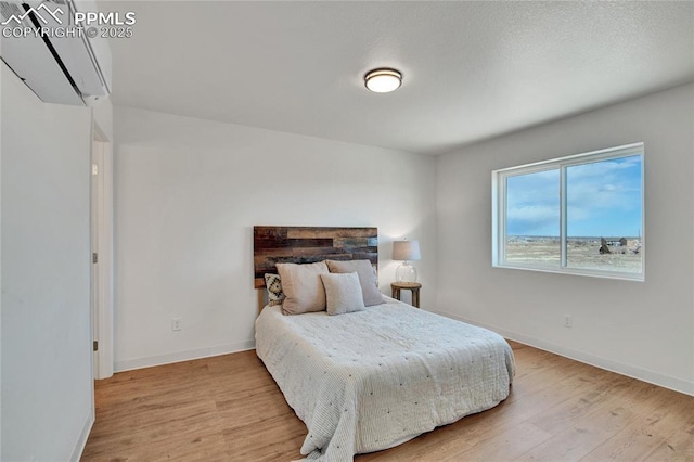 bedroom with light wood finished floors and baseboards