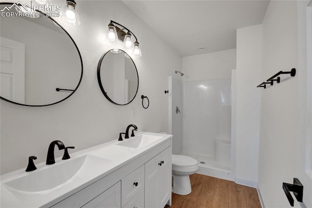 full bath with wood finished floors, walk in shower, toilet, and double vanity