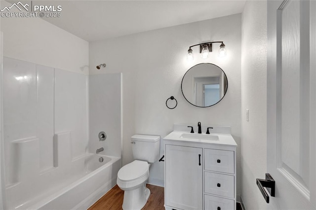 bathroom featuring wood finished floors, toilet, vanity, and shower / washtub combination