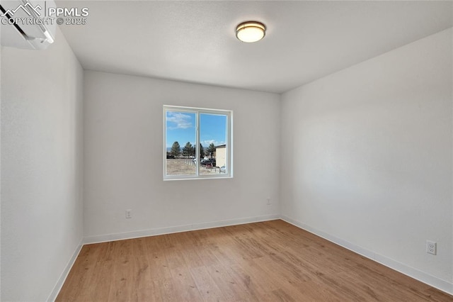 spare room featuring light wood finished floors and baseboards