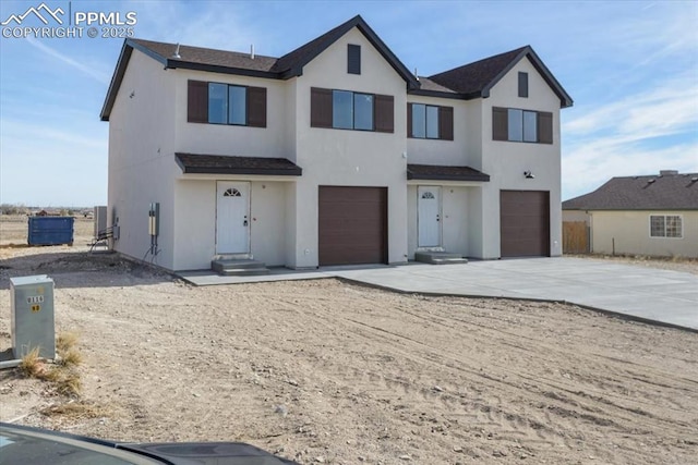 view of front of home with driveway, an attached garage, and stucco siding