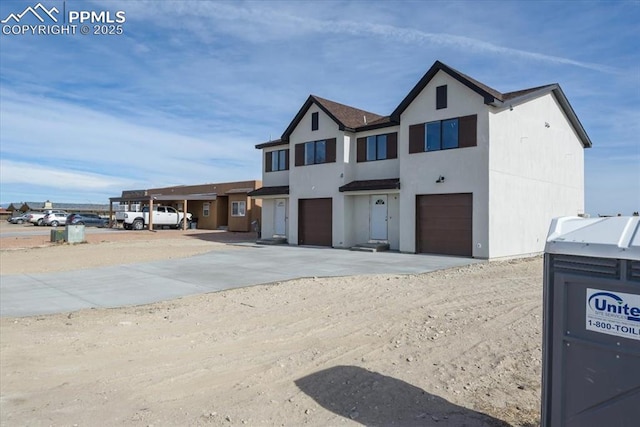 view of front of home featuring concrete driveway, a garage, and stucco siding