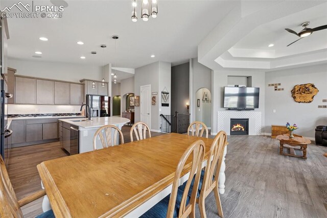 6949 Compass Bend Dr, Colorado Springs, CO 80927 - dining area with light wood-style floors, recessed lighting, and a tile fireplace