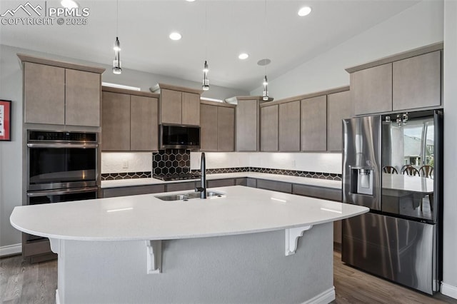 6949 Compass Bend Dr, Colorado Springs, CO 80927 - kitchen with appliances with stainless steel finishes, a breakfast bar, backsplash, dark wood-type flooring, and recessed lighting