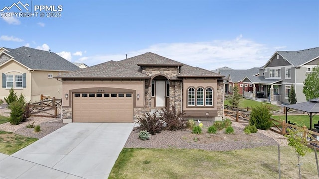 6949 Compass Bend Dr, Colorado Springs, CO 80927 - view of front of property featuring stone siding, an attached garage, concrete driveway, and stucco siding