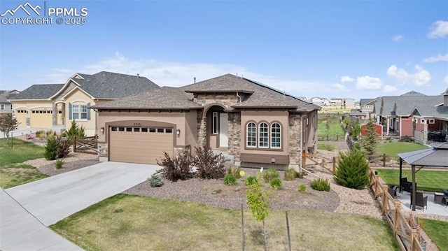 6949 Compass Bend Dr, Colorado Springs, CO 80927 - french provincial home featuring stone siding, an attached garage, driveway, stucco siding, and a gazebo