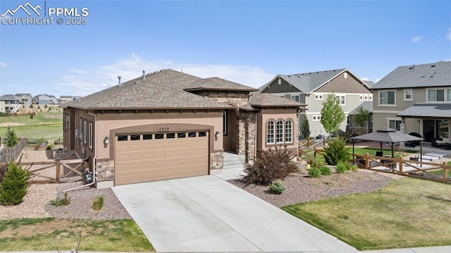 6949 Compass Bend Dr, Colorado Springs, CO 80927 - view of front of property with stone siding, an attached garage, a gazebo, driveway, and a residential view